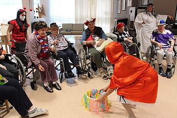 Eine Betreuerin ist als Rotkäppchen verkleidet und spielt mit den BewohnerInnen.