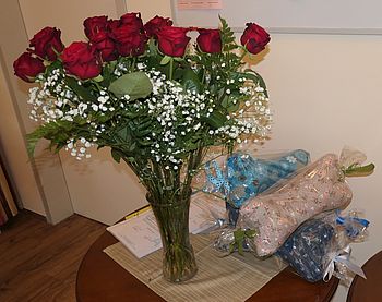 Rote Rosen mit Schleierkraut und Geschenke.
