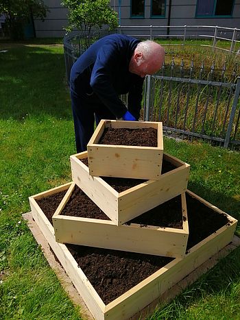 Die Haustechniker haben eine Gemüsepyramide aufgestellt.  Nun müssen verschiedenste Samen in die frische Erde gesetzt werden. 