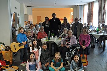Gruppenfoto von Kindern und alten Menschen mit Musikinstrumenten