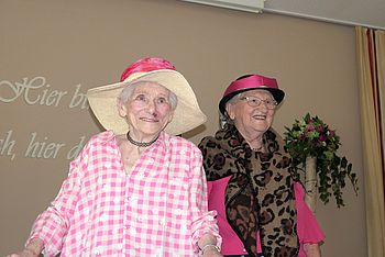 Zwei fröhliche Damen mit Hut.