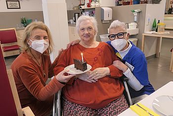 Drei Damen mit einem Stück Torte.