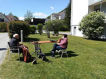 Ein Bewohner und eine Besucherin sitzen im Garten.