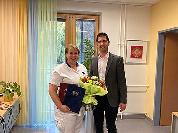 Herr Stephan Zöchling gratuliert Frau Sterkl und überreicht ihr einen Blumenstrauß.
