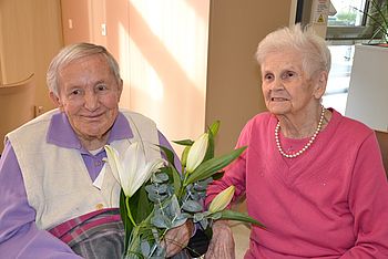 Fr. Karlik gratuliert Fr. Anibas mit einer weißen Lilie zum 100er.