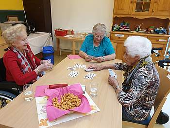 Bewohnerinnen spielen ein Kartenspiel.